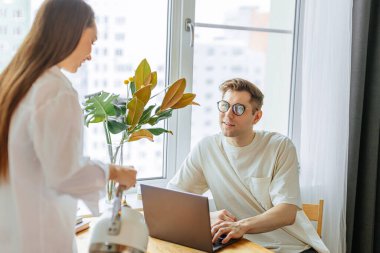 Dikkatli bir kadın kocası için fincana çay doldurur.