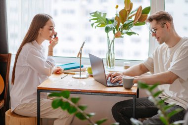 Kocası evde çalışırken güzel bir kadın makyaj yapıyor.