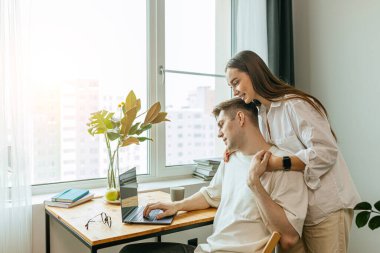 Güzel bir eş, kocasına evde çalışırken destek olur.