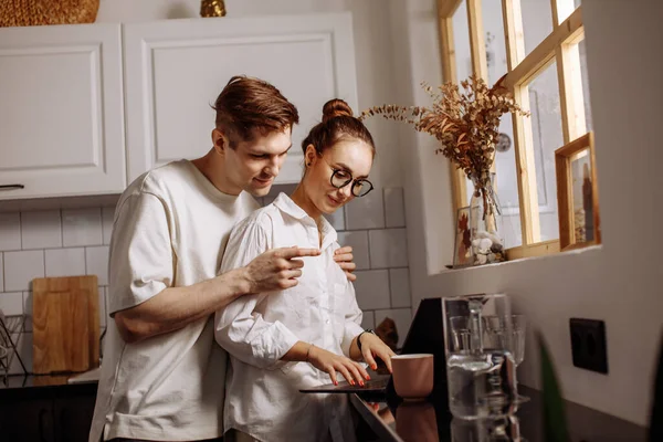 Carinhoso marido abraços trabalhando esposa na cozinha — Fotografia de Stock