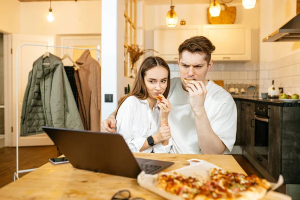 Feliz casal caucasiano comer pizza e assistir filme em casa — Fotografia de Stock