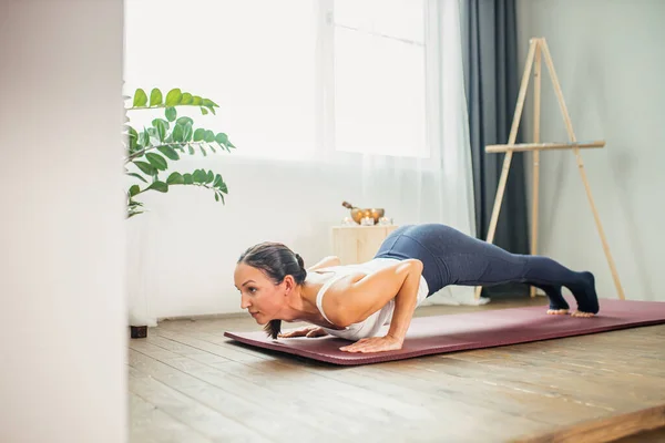 Nő csinál push up miközben gyakorolja otthon — Stock Fotó