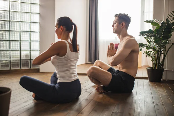Evli çiftler meditasyon yapıyor, evde yoga egzersizleri yapıyor. — Stok fotoğraf