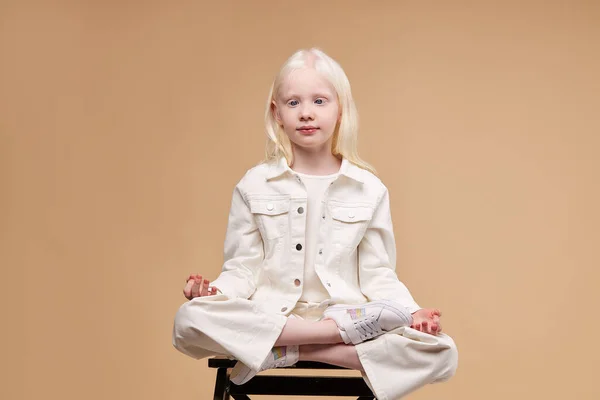 Urocza albinoska modelka medytuje w pozycji lotosu — Zdjęcie stockowe