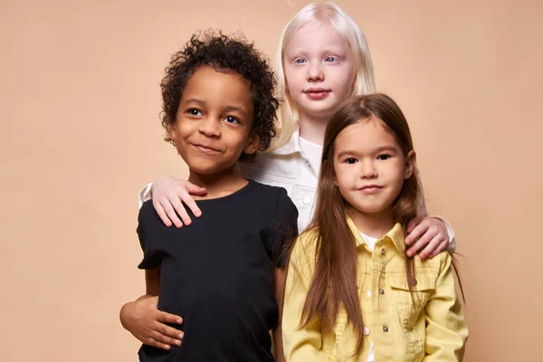 8 anos de idade albino menina abraço mais jovens amigos — Fotografia de Stock