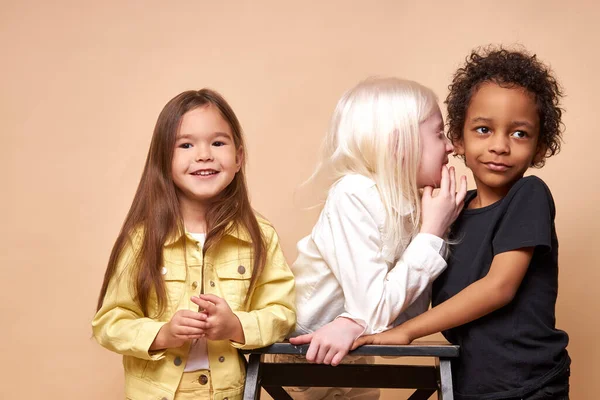 Albino girl tell secret to boy while other girl is listening to them — Stock Photo, Image