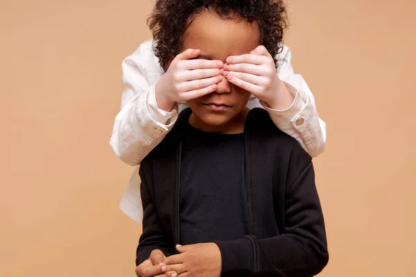 Oidentifierad barn flicka stänga afrikanska pojkar ögon från baksidan — Stockfoto