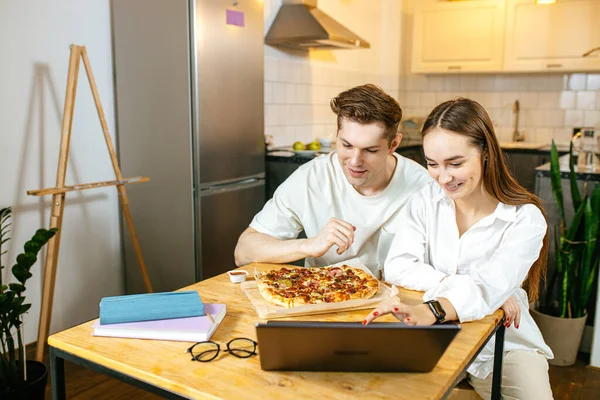 Glückliches kaukasisches Paar isst Pizza und schaut sich Film zu Hause an — Stockfoto