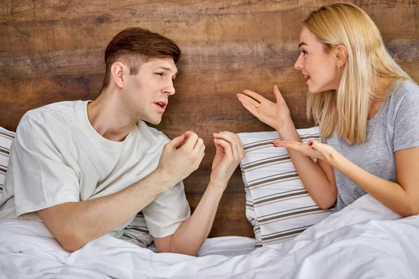 Unglückliches kaukasisches Paar streitet zu Hause im Bett — Stockfoto