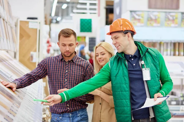 Par kunder bad om hjälp och råd från lagerarbetare — Stockfoto