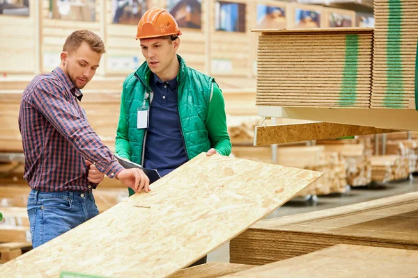 Kunde überprüft Holzbretter auf dem Markt — Stockfoto