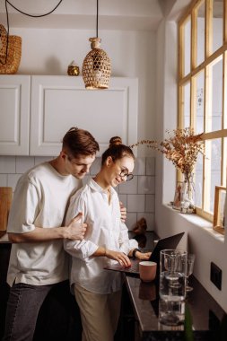 Yakışıklı adam çalışan karısına sarılıyor.