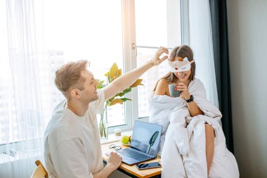 caucasian woman entertains her husband during work at morning clipart