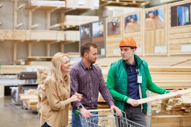 Depo işçisi müşteriler için tahta sunuyor.