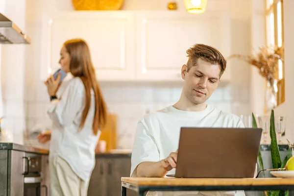 Kobieta rozmawiać przez telefon, podczas gdy jej mąż pracuje w laptopie, freelance — Zdjęcie stockowe