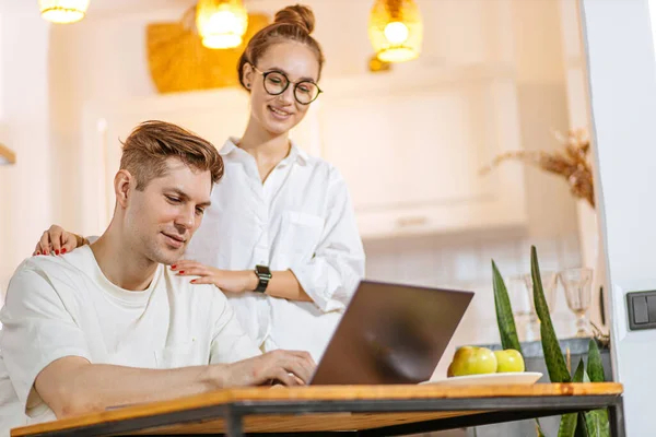 Aantrekkelijke dame ondersteuning echtgenoot terwijl zijn werken thuis — Stockfoto