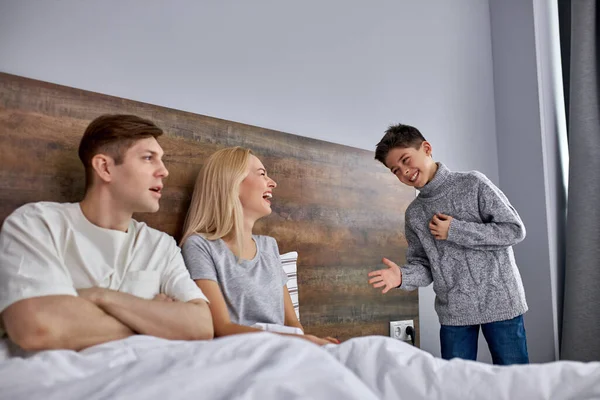 Glad kaukasisk som prata med föräldrar i sängen — Stockfoto