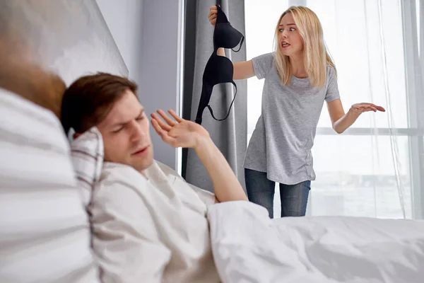 Жена разочарована мужем, она нашла кого-то еще бюстгальтер под кроватью — стоковое фото