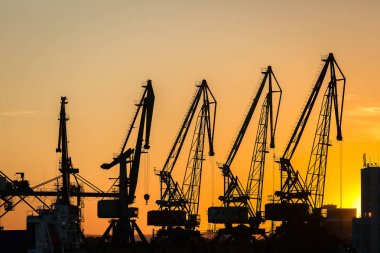 Gün batımında limanda büyük Vinçler siluet