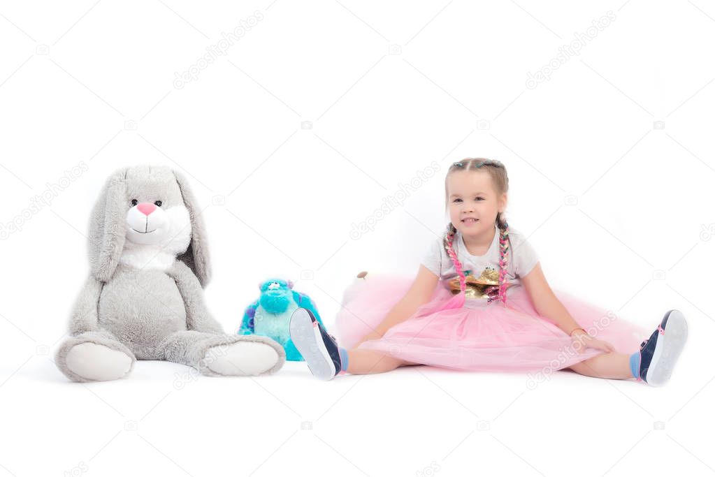 little girl posing together with big toys