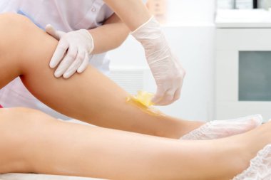 Güzellik salonunda müşterinin ayağında saç çıkarma prosedürü