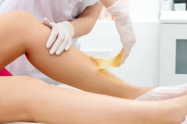 Kosmetické odstranění vlasů procedura na nohou klienta v salonu krásy — Stock fotografie