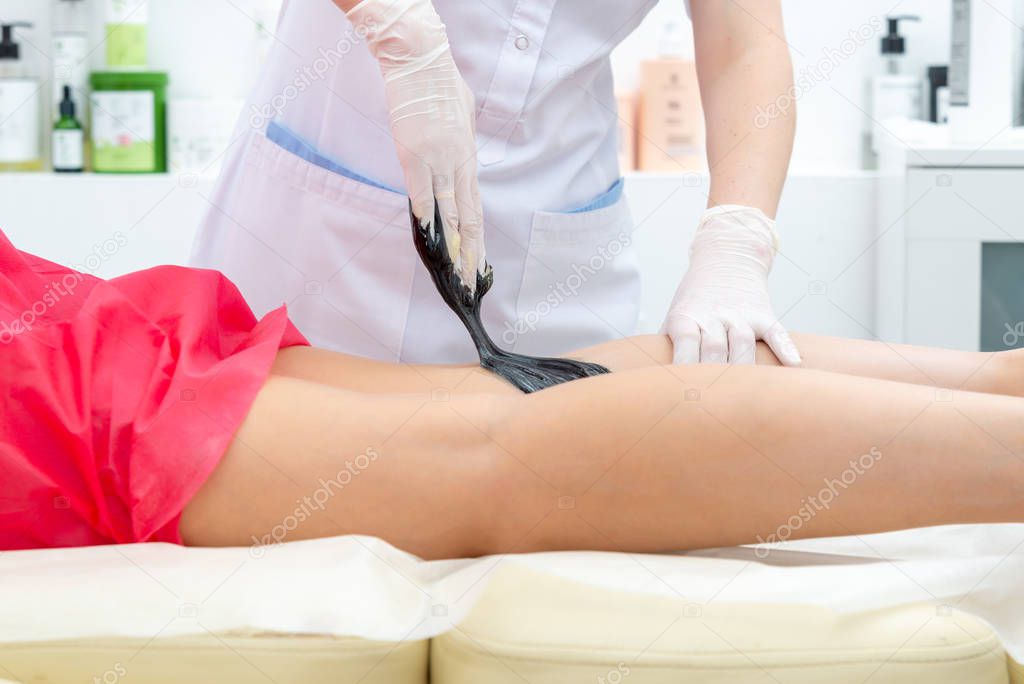 beautician hair removal procedure on the clients feet in beauty parlor