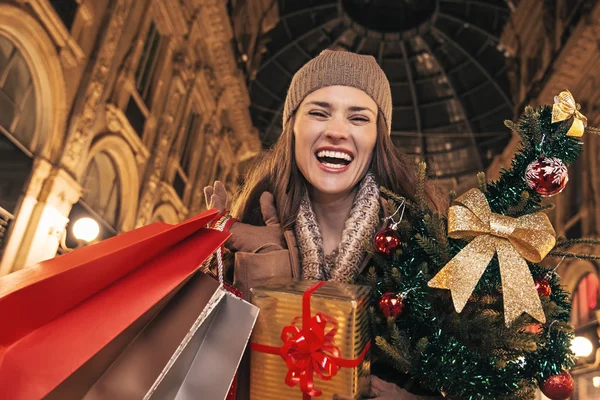 Vrouw met kerstboom en boodschappentassen in Milaan, Italië — Stockfoto