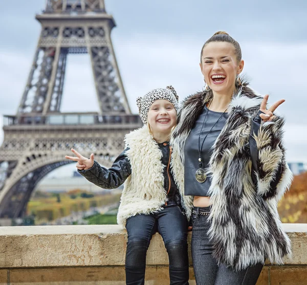 Mother and daughter against Eiffel tower showing victory — Stock Photo, Image