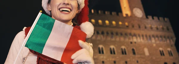 Donna in cappello di Natale con bandiera italiana guardando in lontananza — Foto Stock