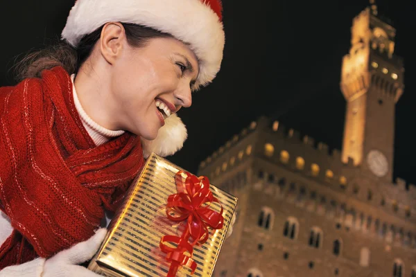 Frau mit Weihnachtsgeschenkschachtel blickt in die Ferne, Florenz — Stockfoto