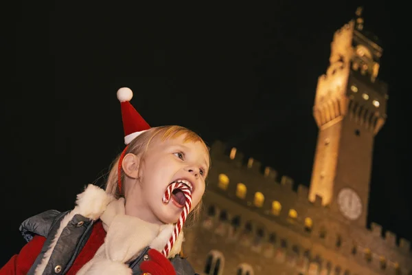 Χαμογελαστό κορίτσι μπροστά από το Παλάτσο Βέκιο διατροφικές Χριστούγεννα από ζαχαροκάλαμο — Φωτογραφία Αρχείου
