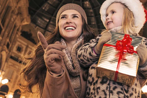 Madre e figlia con regalo di Natale che punta su qualcosa — Foto Stock