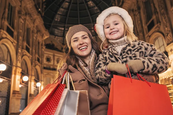 Mamma e bambino in cappello natalizio con shopping bag a Milano — Foto Stock