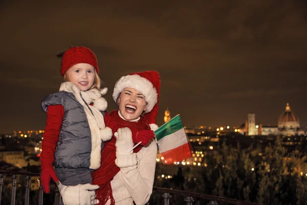 Madre e figlia sorridenti in cappelli natalizi con bandiera italiana — Foto Stock