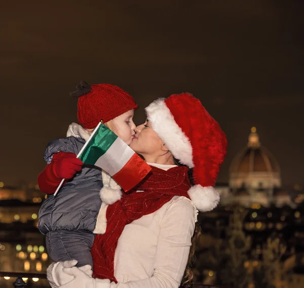 Mère et enfant dans chapeaux de Noël avec drapeau italien baisers — Photo