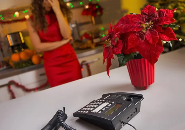 Крупный план телефона на кухонном столе и напряженная женщина в backgroun — стоковое фото