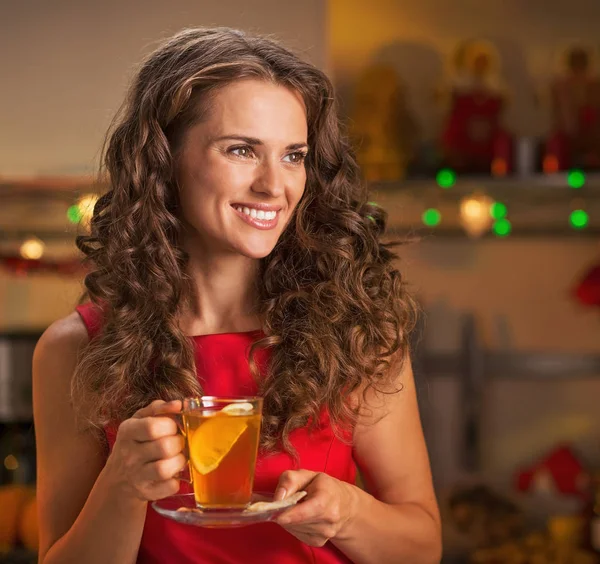 Happy young woman with cup of ginger tea looking on copy space — Stock Photo, Image