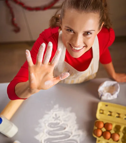 Jonge huisvrouw tonen hand besmeurd in bloem — Stockfoto