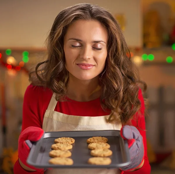 Jovem dona de casa desfrutando panela de biscoitos frescos — Fotografia de Stock