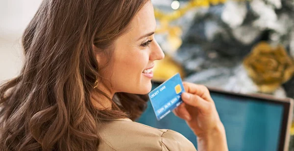 Portret van doordachte jonge vrouw met creditcard en laptop ik — Stockfoto