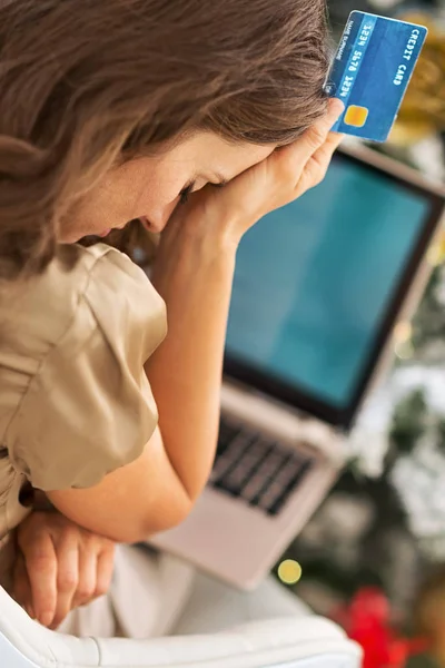 Gestresste junge Frau mit Kreditkarte und Laptop vor der Tür — Stockfoto