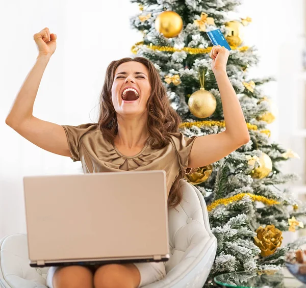 Jovem feliz com cartão de crédito e laptop regozijo — Fotografia de Stock