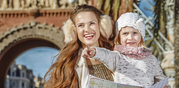 Mother and child near Arc de Triomf holding map and pointing — Stock Photo, Image