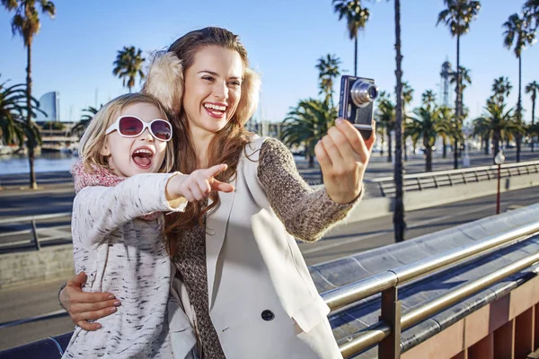 Mother and daughter tourists taking photo with digital camera — Stock Photo, Image