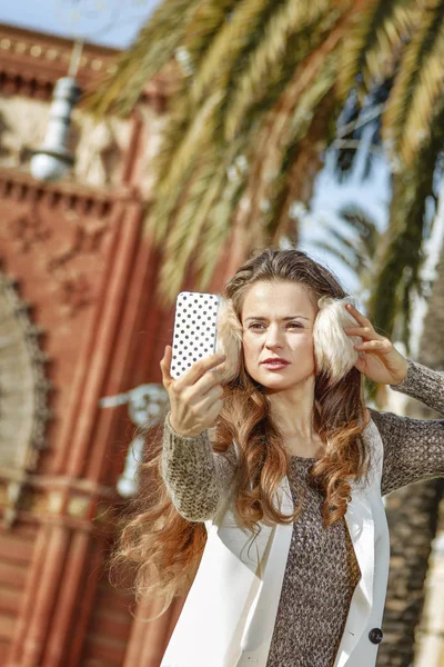 Женщина возле Триумфальной арки делает селфи со смартфоном — стоковое фото
