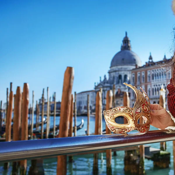 Closeup on Venetian mask in hand of woman on embankment — Stock Photo, Image