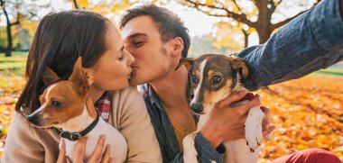 Selfie sonbahar parkta öpüşme sırasında yapma köpeklerle Çift