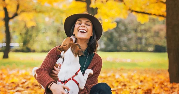 秋の野外で犬と遊ぶ若い女性 — ストック写真