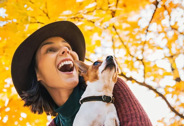 Lykkelig ung kvinde med hund udendørs i efteråret lookin - Stock-foto